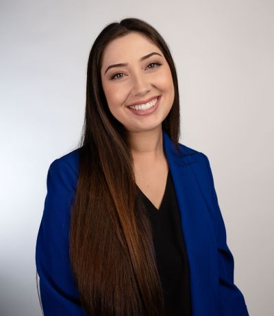 Victoria Yanez A smiling woman with long, dark hair wears a bright blue blazer over a black top, identified as Victoria Yanez, Shop Performance Specialist. Her favorite product is Chocolate Cherry Sno with Oreo.