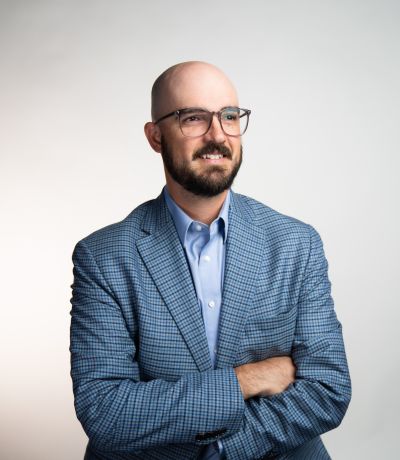 Matt Ewing A smiling man with a bald head, beard, and glasses, wearing a blue plaid blazer over a light blue collared shirt with his arms crossed, identified as Matt Ewing, Director of Research & Development. His favorite product is Natural Coconut Sno with Fresh Lime Juice.