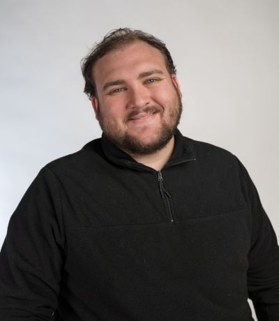 Quinn Sharp A smiling man with short dark hair and a beard, wearing a black quarter-zip long-sleeved shirt, identified as Quinn Sharp, Software Development Specialist. His favorite product is Oreo Sno.